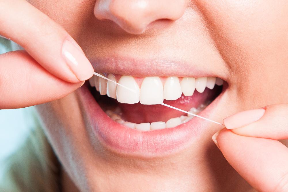 patient flossing teeth | southampton dentist