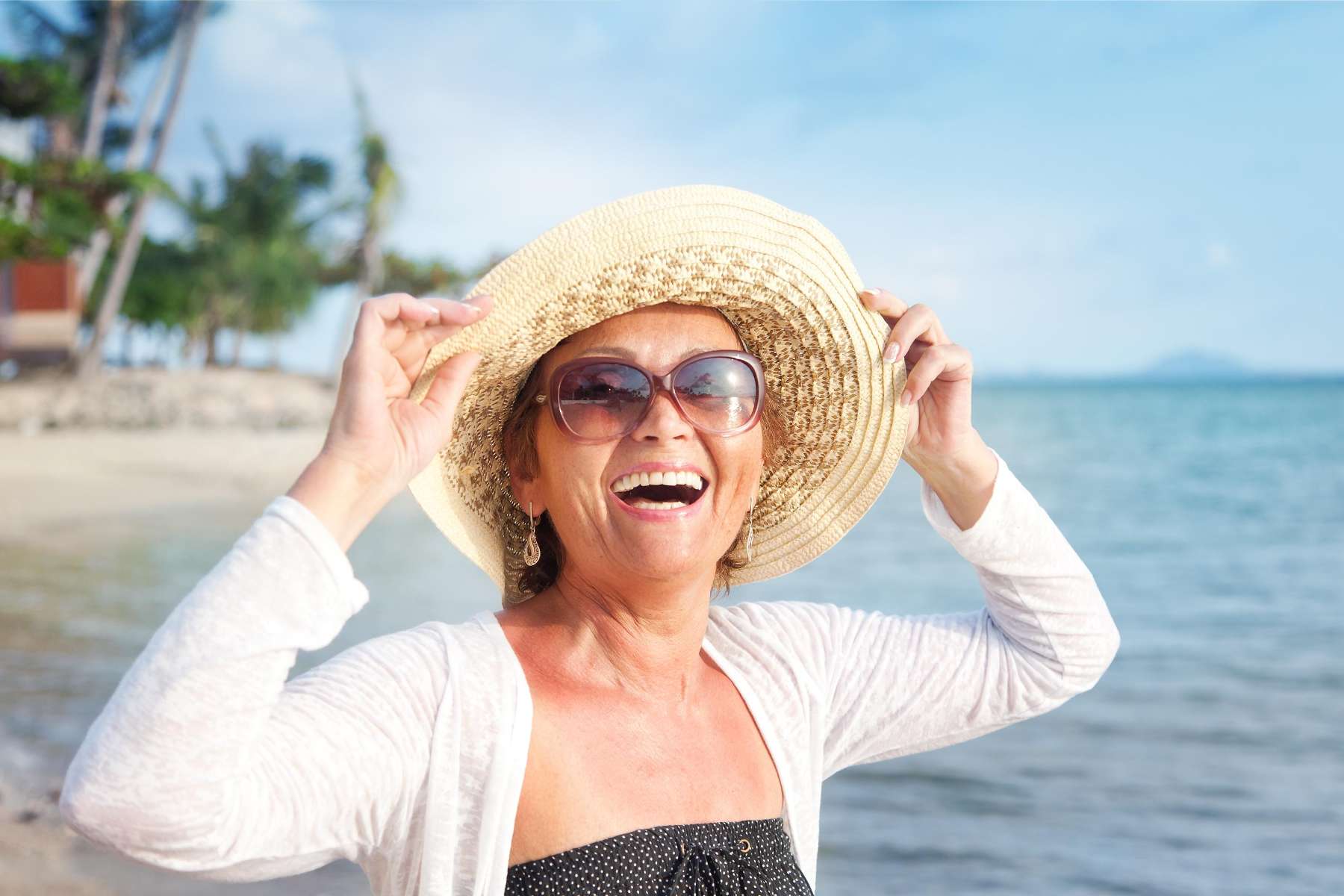 Woman with dental implant in Southampton enjoying the beach