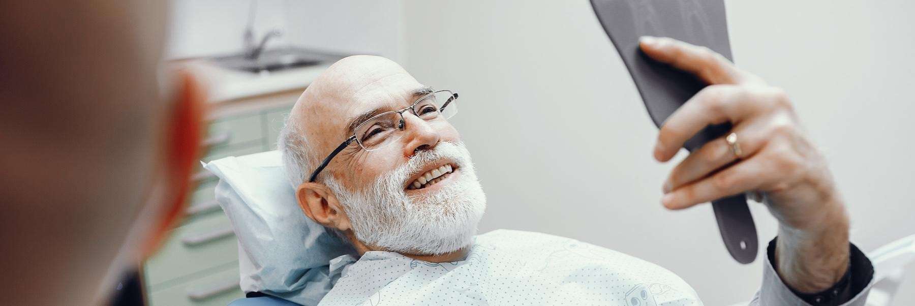 older man looking in mirror | dental implants southampton